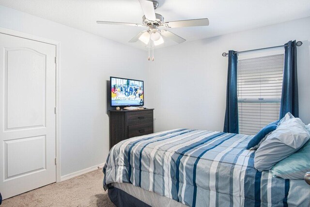 carpeted bedroom with a ceiling fan and baseboards