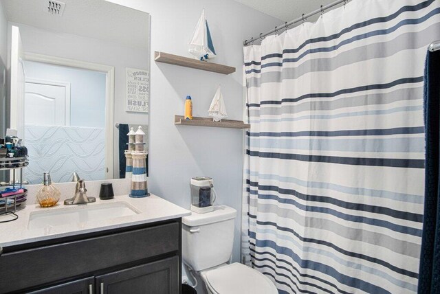 full bath with vanity, toilet, a shower with curtain, and visible vents