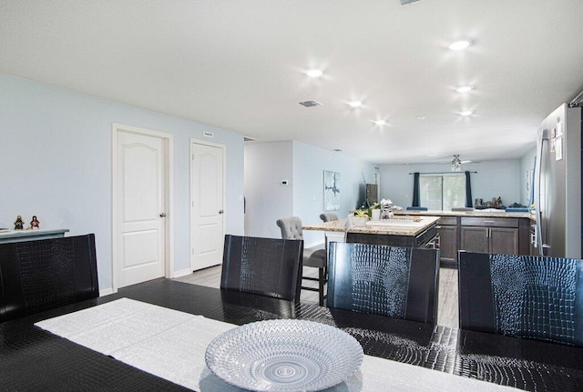 kitchen with a kitchen island, open floor plan, light countertops, a ceiling fan, and a sink