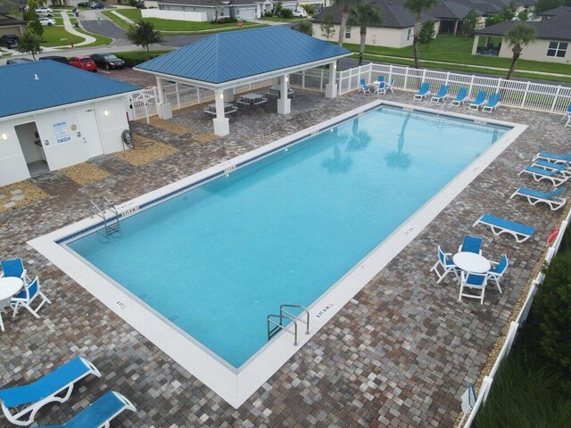 community pool with a gazebo, a residential view, a patio, and fence