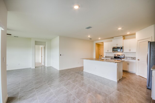 kitchen with visible vents, a center island with sink, white cabinetry, recessed lighting, and stainless steel appliances