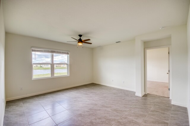 unfurnished room with visible vents, baseboards, and ceiling fan