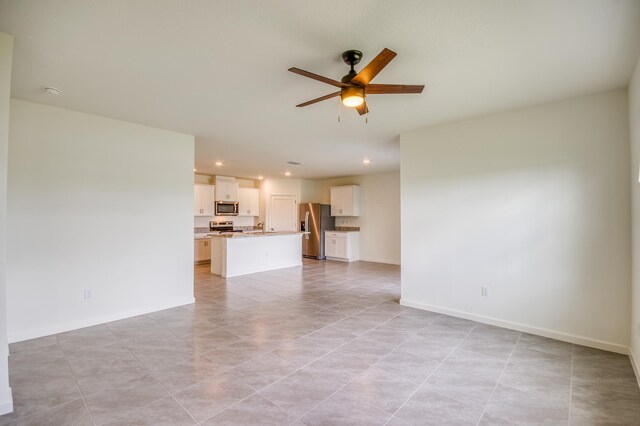 unfurnished living room featuring recessed lighting, a ceiling fan, and baseboards