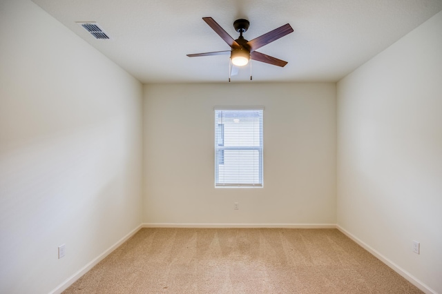 unfurnished room featuring light carpet, visible vents, baseboards, and a ceiling fan