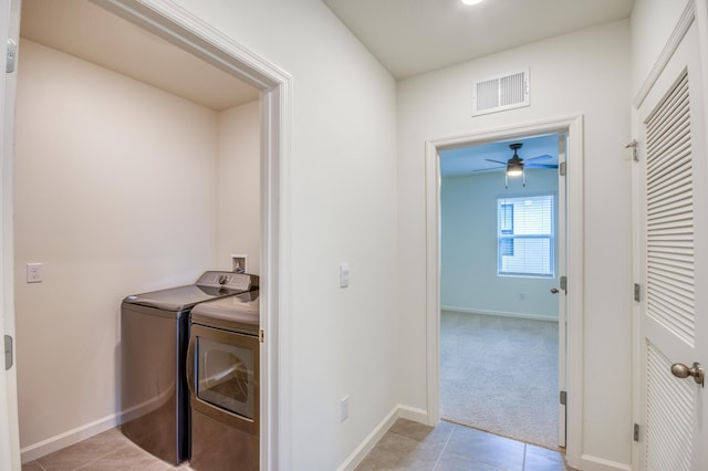 laundry room featuring light tile patterned floors, visible vents, laundry area, separate washer and dryer, and light colored carpet