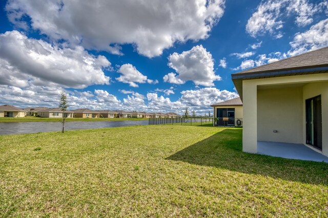 view of yard with a residential view, a water view, and fence