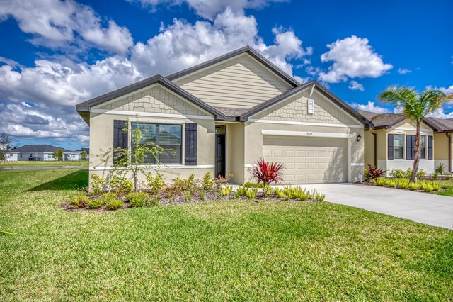 view of front of house featuring stucco siding, driveway, an attached garage, and a front yard