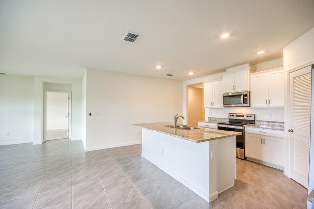 kitchen with visible vents, a kitchen island with sink, a sink, recessed lighting, and stainless steel appliances