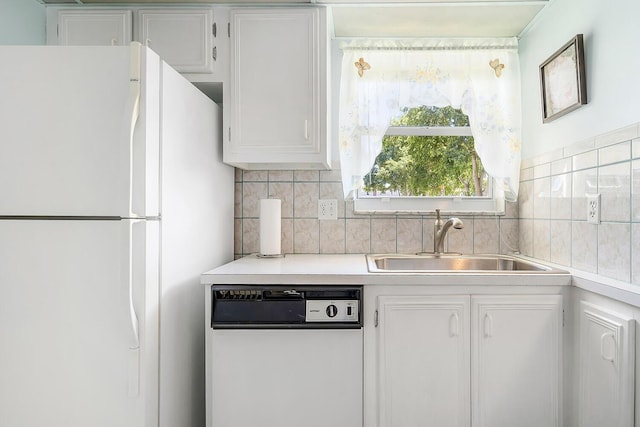 kitchen featuring white appliances, a sink, light countertops, white cabinets, and backsplash