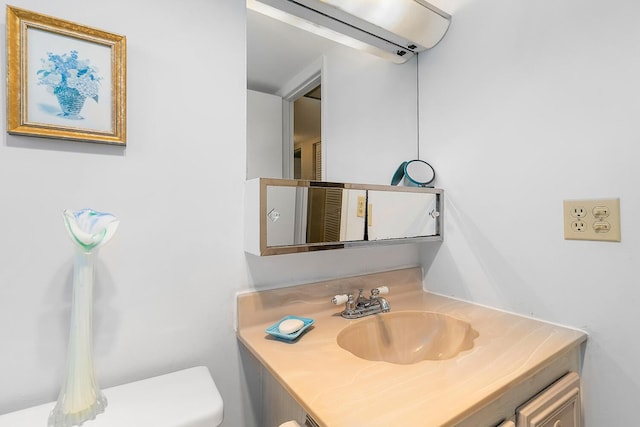 bathroom featuring toilet, vanity, and a wall unit AC