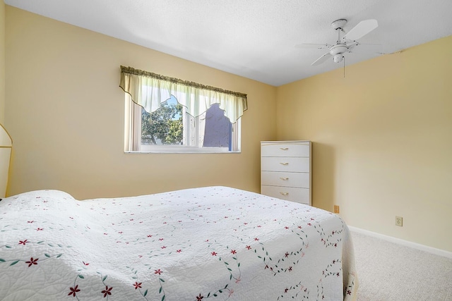 carpeted bedroom featuring baseboards and a ceiling fan