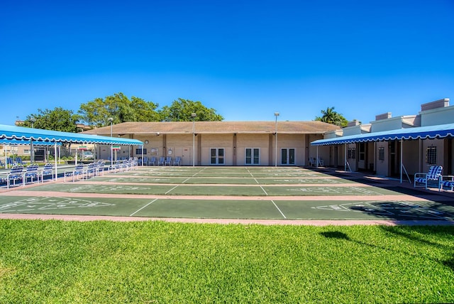 view of home's community featuring a lawn and shuffleboard