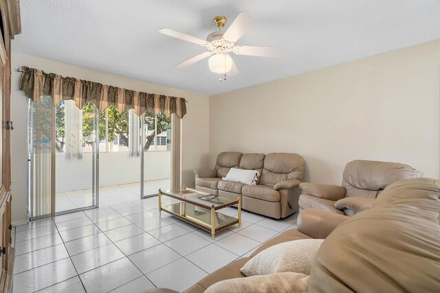 living room with light tile patterned floors, a textured ceiling, and a ceiling fan