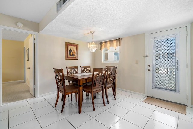 dining space with visible vents, baseboards, a textured ceiling, and light tile patterned flooring