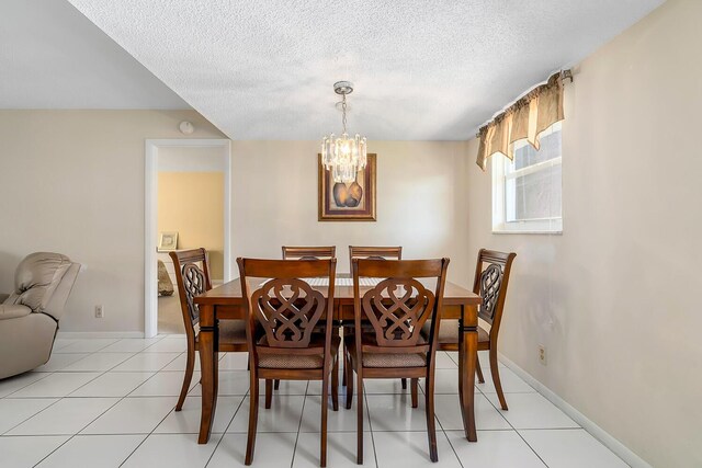 dining room with baseboards, a notable chandelier, light tile patterned flooring, and a textured ceiling