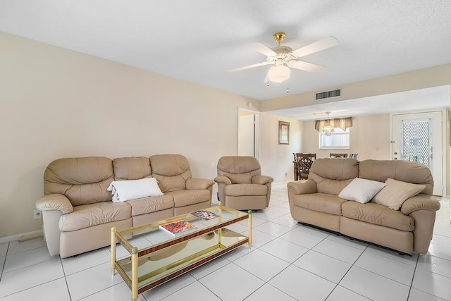 living area featuring light tile patterned floors, visible vents, baseboards, and a ceiling fan