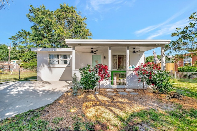 view of front of property with stucco siding, a ceiling fan, and fence