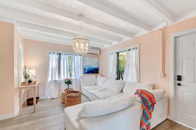 living area featuring light wood finished floors, beam ceiling, an AC wall unit, and a chandelier