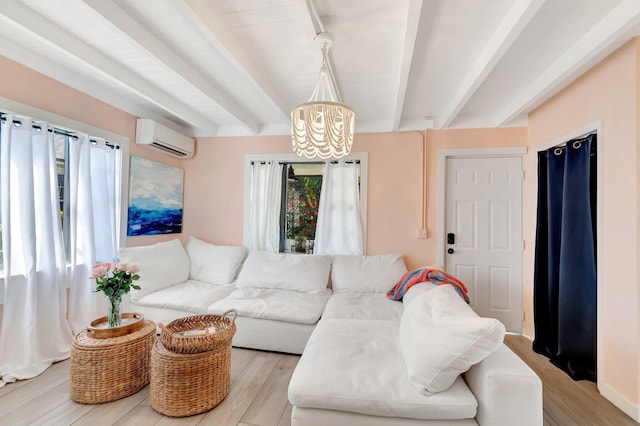 living area with a wall unit AC, a notable chandelier, light wood-style floors, and beam ceiling