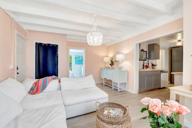 living area featuring beam ceiling, a notable chandelier, and light wood finished floors