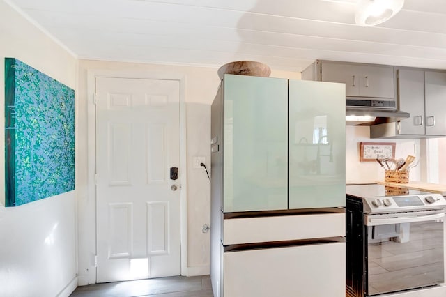 kitchen with under cabinet range hood, stainless steel electric range, gray cabinetry, and freestanding refrigerator