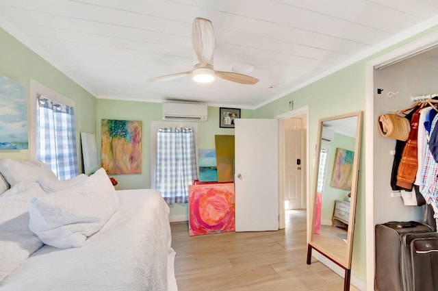 bedroom with ceiling fan, light wood-style floors, a wall unit AC, and ornamental molding