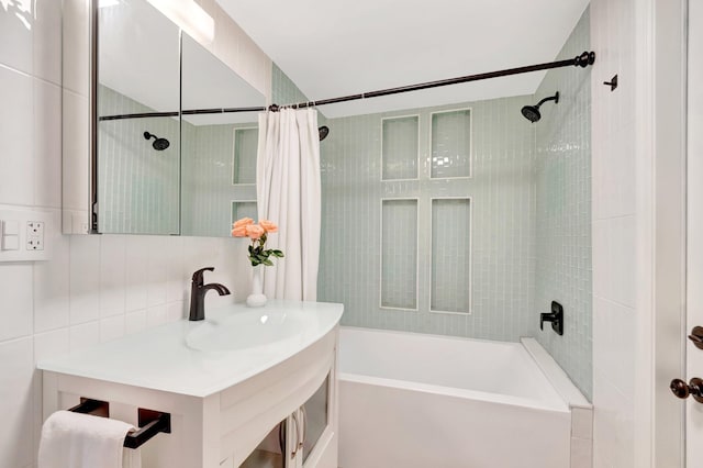 bathroom with backsplash, tile walls, vanity, and shower / bath combination with curtain