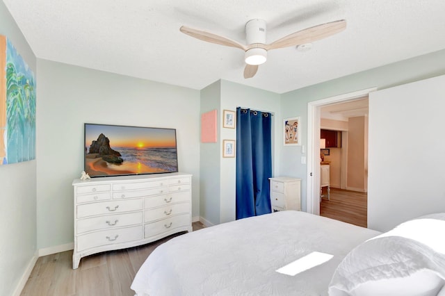 bedroom with a ceiling fan, baseboards, and wood finished floors