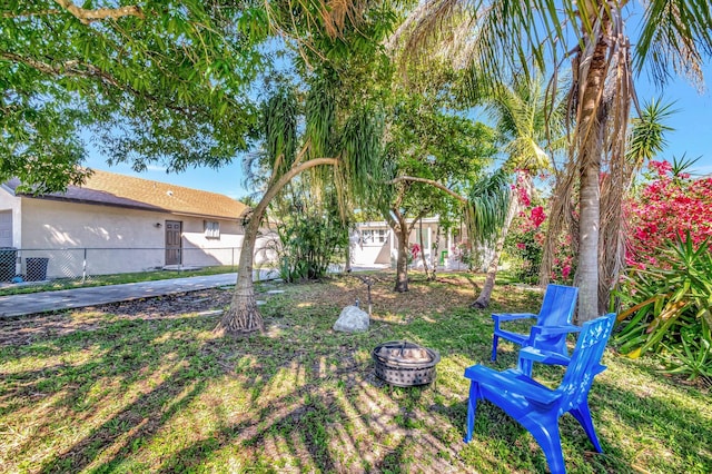 view of yard featuring a fire pit and fence