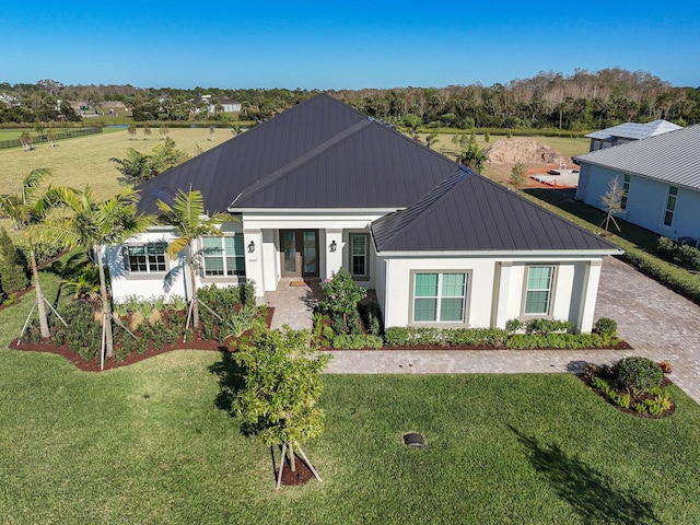 modern farmhouse featuring stucco siding, a front lawn, metal roof, and a standing seam roof