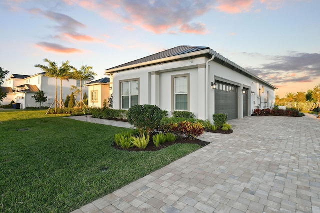 20017 SE Bridgewater Dr, Jupiter, FL 33458 - view of front of home with a standing seam roof, an attached garage, metal roof, a front yard, and decorative driveway