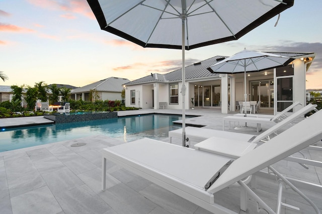20017 SE Bridgewater Dr, Jupiter, FL 33458 - pool at dusk with a patio and a pool with connected hot tub