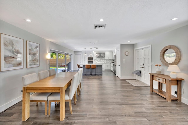 dining area featuring dark wood-type flooring, recessed lighting, baseboards, and visible vents