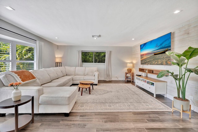 living area with visible vents, a healthy amount of sunlight, and wood finished floors