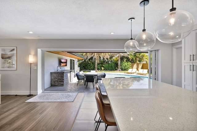 dining area featuring wood finished floors, baseboards, and a textured ceiling