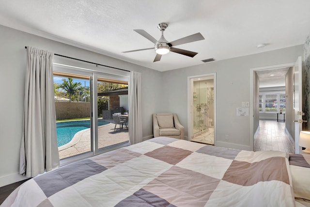 bedroom featuring baseboards, ensuite bathroom, wood finished floors, a textured ceiling, and access to outside