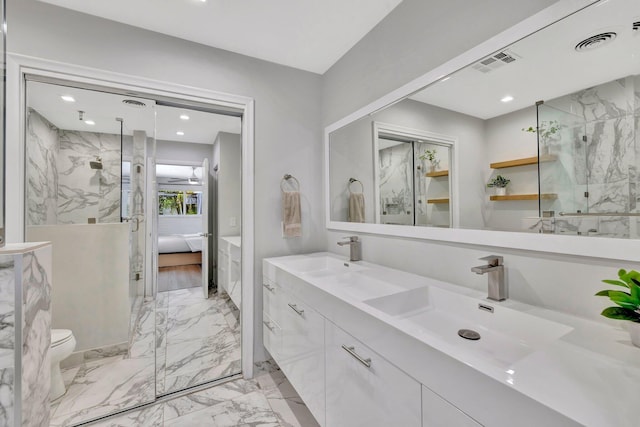 bathroom featuring visible vents, a marble finish shower, and a sink