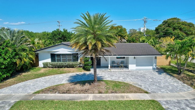 view of front of house with decorative driveway, a garage, and stucco siding