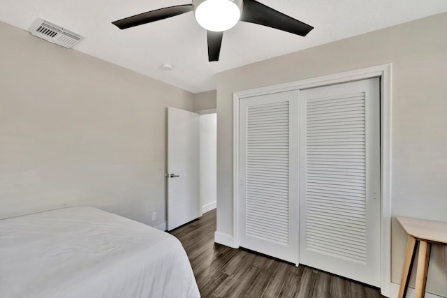 bedroom featuring a ceiling fan, wood finished floors, visible vents, baseboards, and a closet