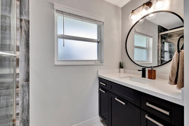 bathroom featuring baseboards, tiled shower, and vanity