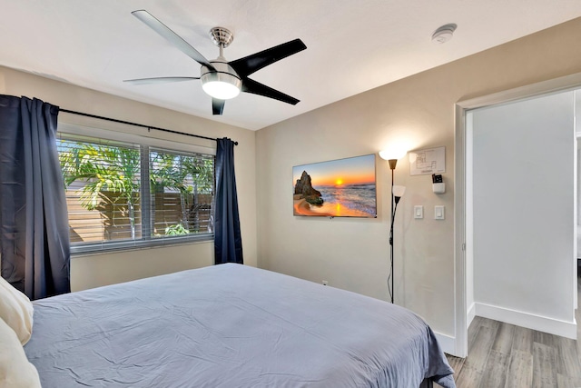 bedroom with wood finished floors, baseboards, and ceiling fan