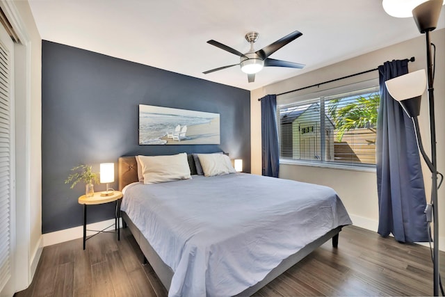 bedroom featuring a ceiling fan, baseboards, and wood finished floors