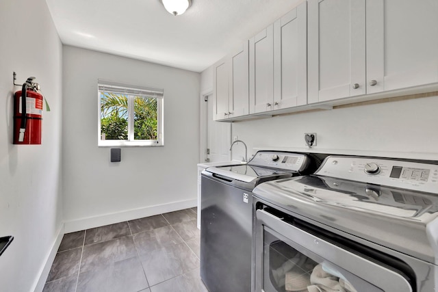 clothes washing area with washer and dryer, tile patterned floors, cabinet space, and baseboards