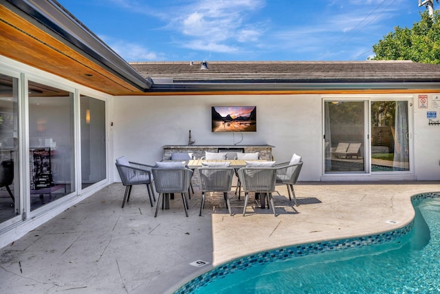 outdoor pool with a patio area and outdoor dining space