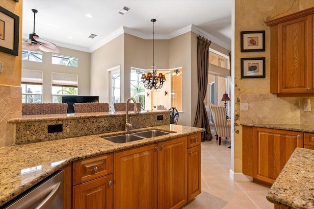 kitchen with crown molding, light tile patterned floors, ceiling fan with notable chandelier, brown cabinetry, and a sink