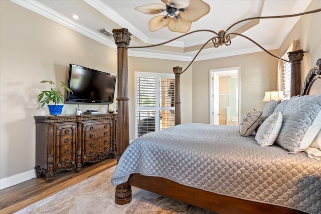 bedroom with crown molding, wood finished floors, and visible vents