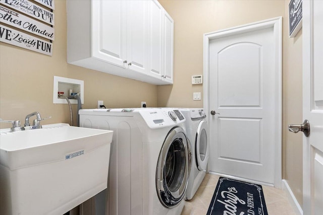 laundry room featuring washer and clothes dryer, light tile patterned flooring, cabinet space, and a sink