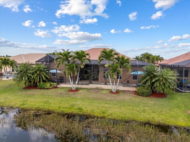 back of property with glass enclosure, a tiled roof, a yard, and stucco siding