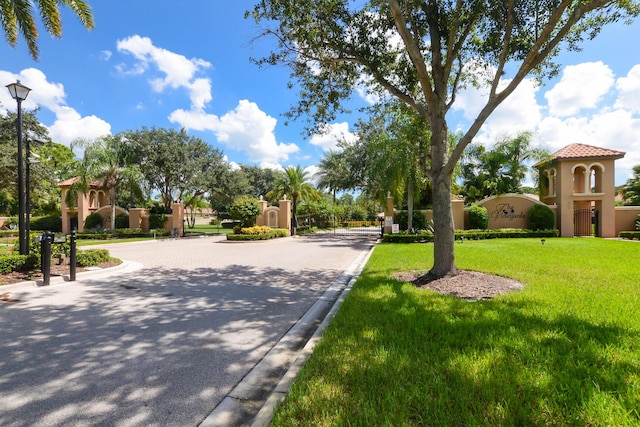 surrounding community featuring a yard and curved driveway