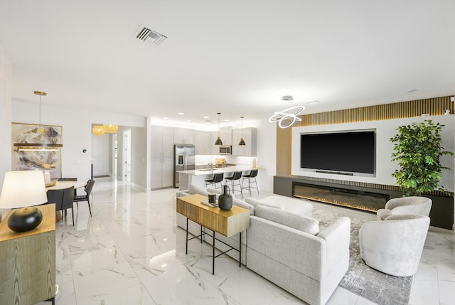 living room with a notable chandelier, visible vents, marble finish floor, and recessed lighting